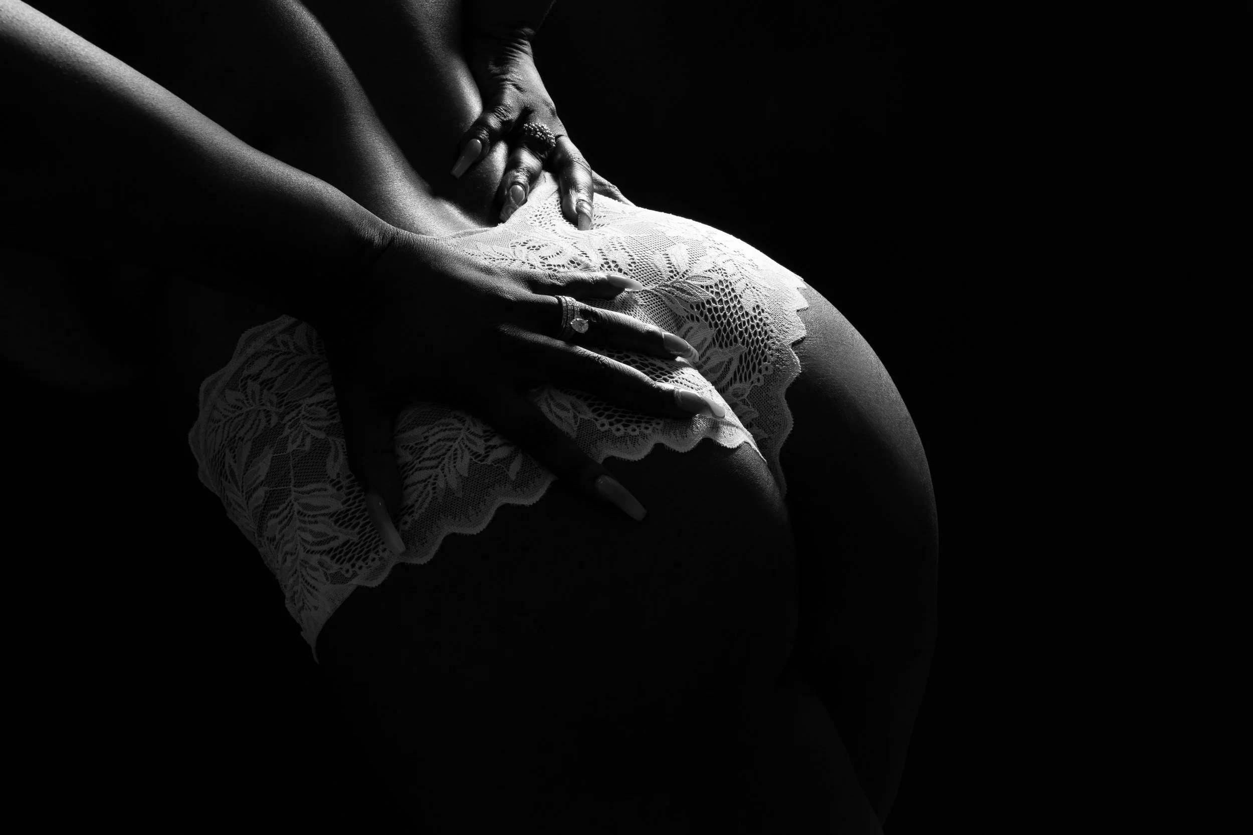 Detalle artístico en blanco y negro de encaje y manos